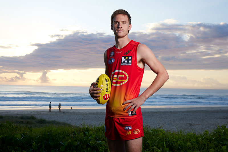 Gold Coast Suns player holding an AFL football